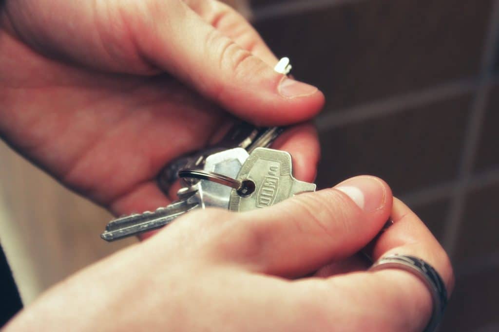 Hand holding keys to house door